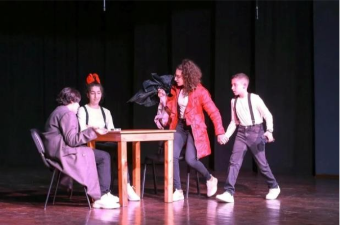 Tiyatro sahnesinde öğrenciler